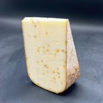 Fromage Far Aqui Fenu Grec sur surface noire, tranche de 450g. Fromage de brebis thermisé, saveur de noix en fin de bouche, origine France.