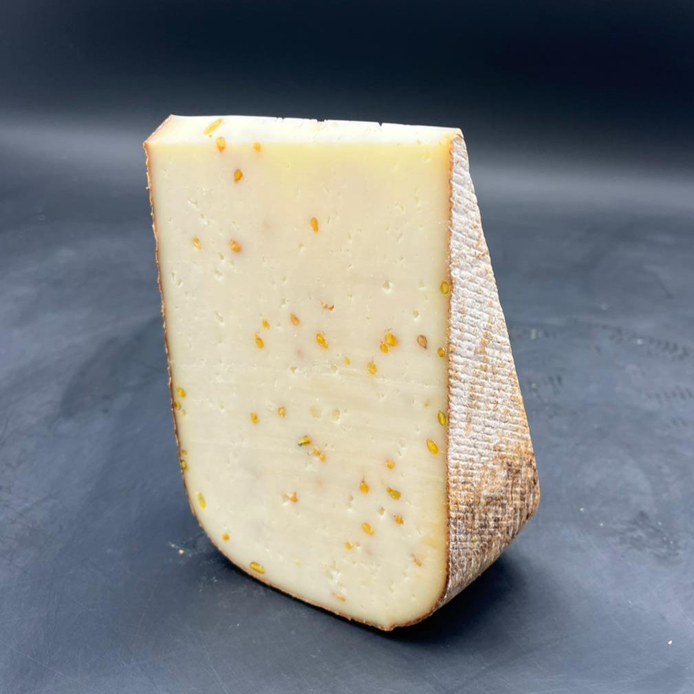 Fromage Far Aqui Fenu Grec sur surface noire, tranche de 450g. Fromage de brebis thermisé, saveur de noix en fin de bouche, origine France.